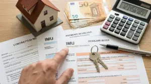 Documenti IMU e cedolare secca con una casa in miniatura, chiavi, soldi e calcolatrice